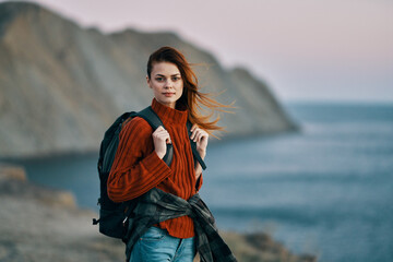 woman with backpack on her back travel tourism sweater ocean sea mountains