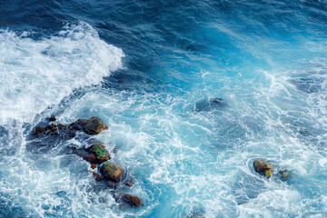 crushing sea waves texture. beautiful nature background view from above. unbelievable blue color of...