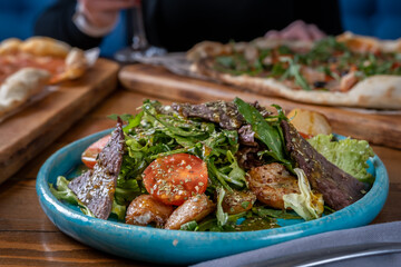 Healthy green salad with fried beef, tomato and greens