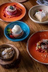 Wood table full of cakes, fruits, coffee and different desserts.