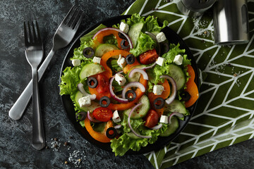 Concept of delicious food with Greek salad on black smokey background