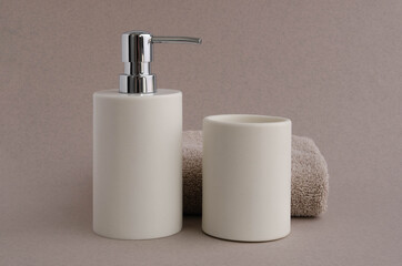 Fototapeta na wymiar Bath set soap dispenser and towel. Hygiene and health concept
