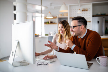 Happy successful business partners working at meeting in office