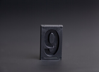 letterpress number nine on black background