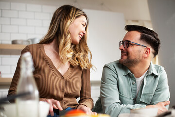 Happy smiling couple cooking together. Boyfriend and girlfriend preparing pasta at home