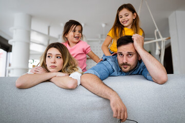Tired mother and father, couple feels annoyed exhausted with noisy children