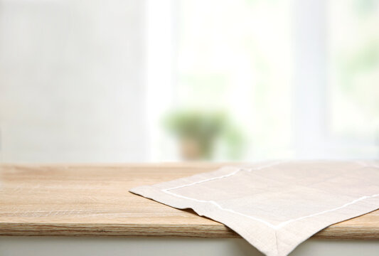 Empty space table decorated with beige towel food advertisement display. Tabletop. Blurred kitchen backdrop. Food promotion background.