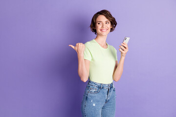 Profile side view portrait of nice cheerful girl holding in hands using device browsing showing copy space isolated over violet color background