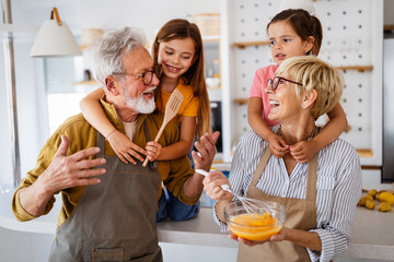 Cheerful family spending good time together while cooking in kitchen