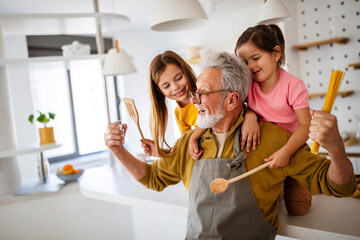 Happy senior couple having breakfast with their grandchildren at home