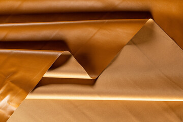 surface with folds of artificial leather for caramel-colored garments