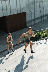Sportive couple during workout stair running outdoors