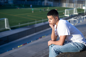 Football fan bored while sitting on stadium bleachers