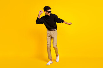 Photo of funky sweet dark skin man wear black sweater eyewear dancing isolated yellow color background