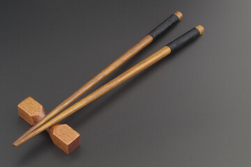 Wooden chopsticks on black table close up, copy space for text.