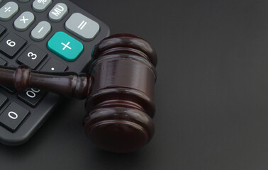 Wooden judge gavel on calculator, arbitration theme