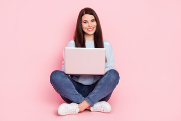 Naklejka premium Full size photo of nice optimistic brunette hairdo lady sit type laptop wear shirt jeans sneakers isolated on pink color background