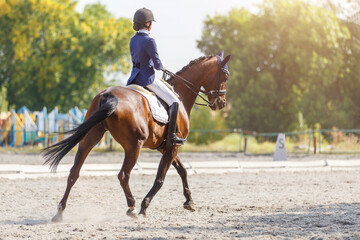 Young girl riding horse at dressage advanced test