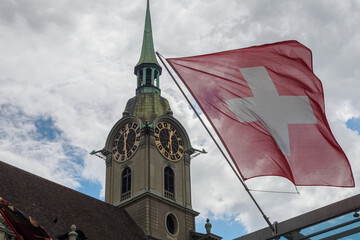 View of Holy Spirit Church (Heiliggeistkirche) and Switzerland flag in Bern Switzerland