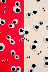 Lots of toy eye emojis on a multi-colored background split in half