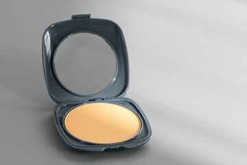 Open box with make up face powder on gray background