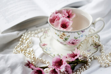 cup with green tea and peach flowers. Photo
