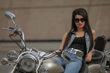 Fototapeta na wymiar Portrait of young woman on a motorcycle
