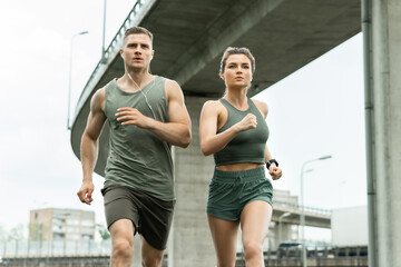 Fototapeta na wymiar Sportive couple during jogging workout on city street