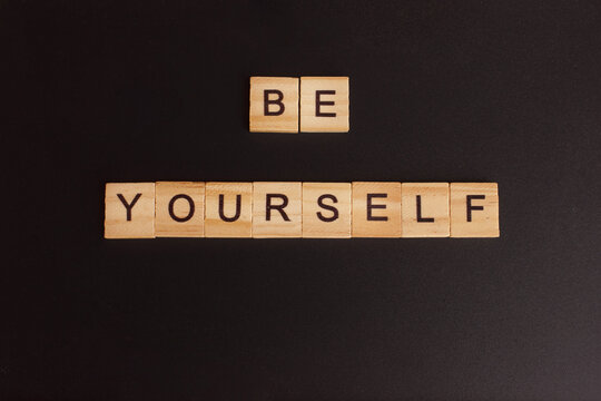 Wooden block letters written phrase be yourself on blackboard background. Concept mental health journaling, healthy mindset, accepting myself