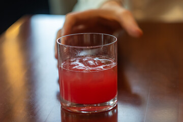 a man's hand reaches for a cocktail glass