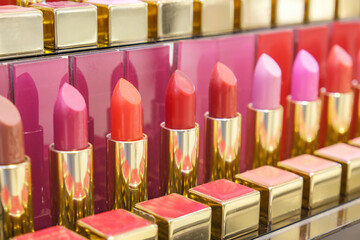 Cosmetic counter with lipstick in vibrant reds. Fashion and beauty industry, decorative cosmetics.