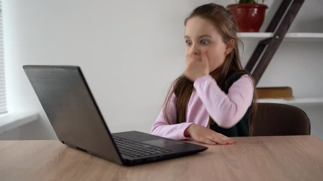 Realistic scare horror reaction of Caucasian teenage girl watching video on computer screen. Internet addiction in school and adolescent children. Mental condition.