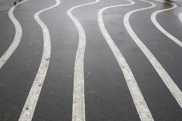 White zigzag stripes on the wet asphalt.
