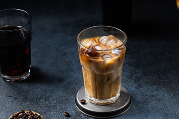 Iced coffee in a tall glass with cream poured over. Iced latte. Cold summer drink. Cold brew in...