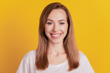 Close-up of a woman toothy beaming smiling on yellow background
