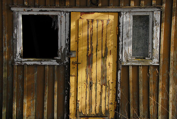 old wooden facade with door between two windows