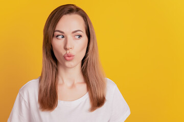 Fototapeta premium Close-up portrait of excited amazed beautiful girl send air kikss on yellow background