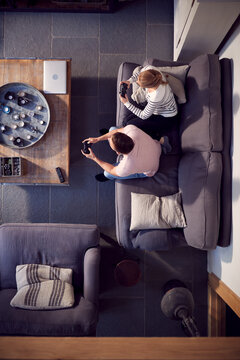 Overhead View Of Couple Relaxing On Lounge Sofa At Home And Playing Computer Game Together