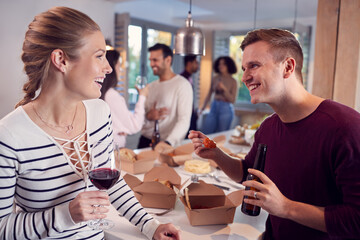 Group Of Multi Cultural Friends Enjoying Drinks Party With Takeaway Food At Home Together