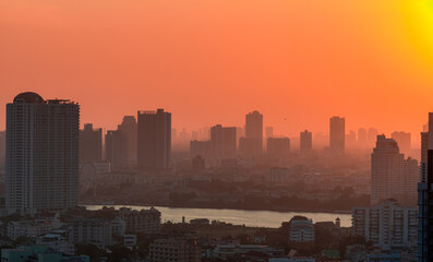 Cityscape with polluted air. Air pollution. Smog and fine dust covered city in the morning with orange sky. Environmental problem in big city. Toxic fine dust. Unhealthy air. Urban unhealthy living.