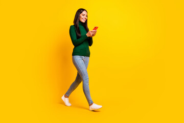 Fototapeta na wymiar Full size profile side photo of young happy cheerful good mood girl go walk with phone isolated on yellow color background
