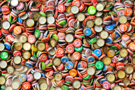 Collection of Bottle caps decorated with logos of many brand beverages sold in Thailand.