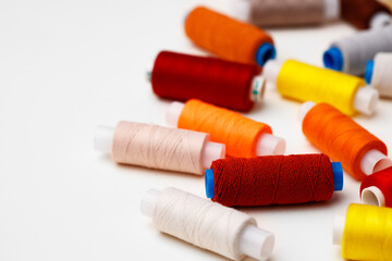 Colored spools of threads on white background
