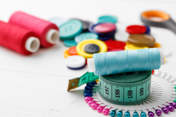 Colorful sewing accessories on white wooden table