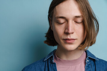 Young european man posing at camera with eyes closed