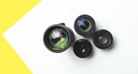 Modern camera lenses with reflections, white yellow background