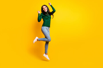 Fototapeta na wymiar Full length photo of cheerful victorious woman jump up raise fists winner isolated on yellow color background