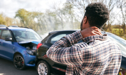 Young Male Driver With Whiplash Injury Standing By Damaged Car After Road Traffic Accident - obrazy, fototapety, plakaty