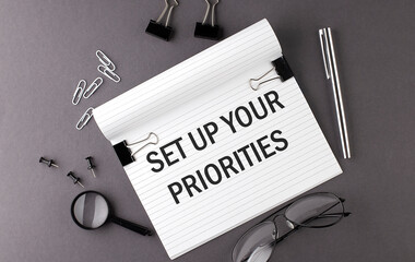 Text SET UP YOUR PRIORITIES on Notebook and office tools on the gray desktop