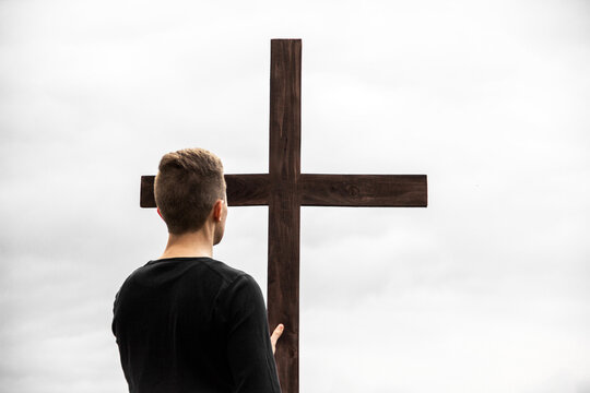 A man near the cross. Man believes in God. Hope in God